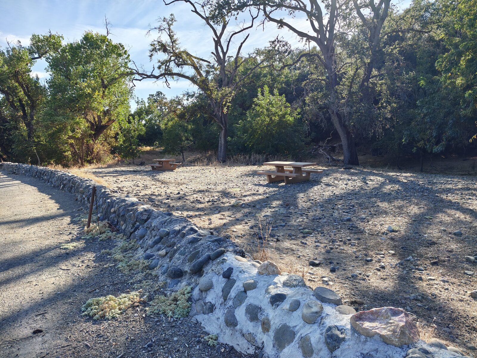 Picnic tables beside the rock wall